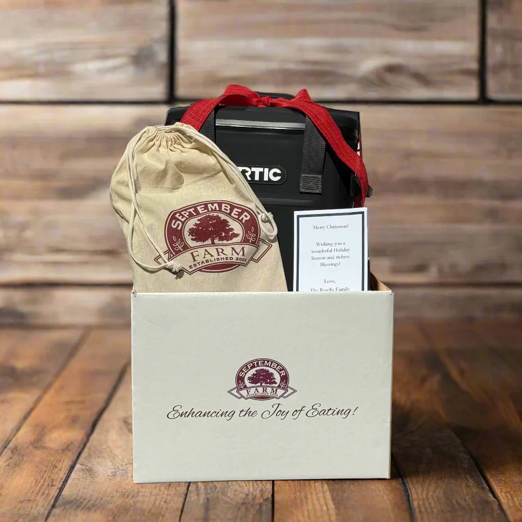 Gift box with September Farm branded items on a wooden surface