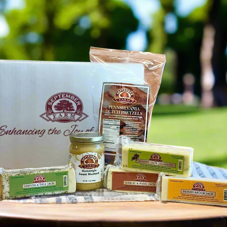 September Farm food products including pretzels, cheese, and other items on a table outdoors.