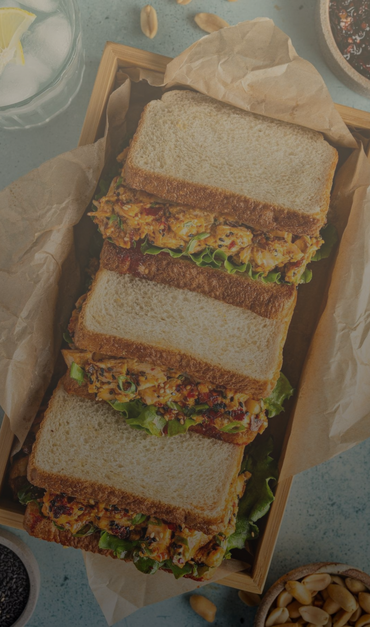 Stack of sandwiches on a wooden board with a light background

Details